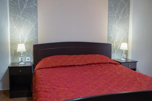 a bedroom with a red bed with two night stands at Ydraktis in Órma