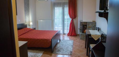 a small bedroom with a red bed and a window at Ydraktis in Órma