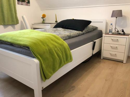 a bedroom with a bed with a green blanket on it at Messezimmer 4u in Düsseldorf