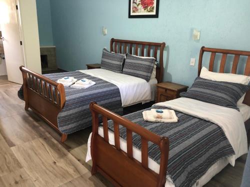 two beds in a room with blue walls at Pousada Recanto das Orquideas in Santo Antônio do Pinhal