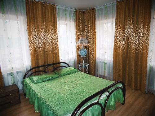 エイスクにあるSeparate houseのベッドルーム1室(緑のシーツとカーテンが備わるベッド1台付)