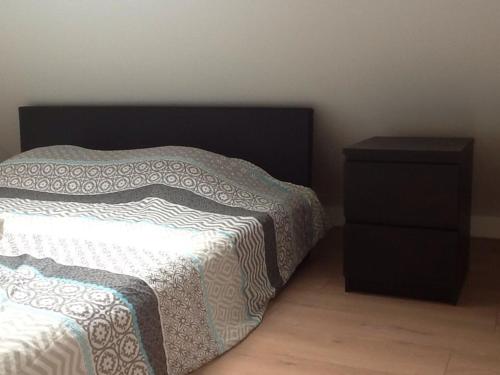 1 dormitorio con cama y mesita de noche en Akker duplex, en Mortsel