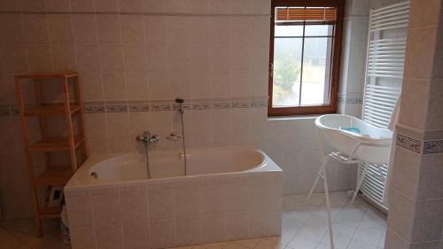 a bathroom with a tub and a sink and a window at Villa Park Lipno 206 in Lipno nad Vltavou