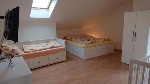 two beds in a small room with a window at Villa Park Lipno 206 in Lipno nad Vltavou