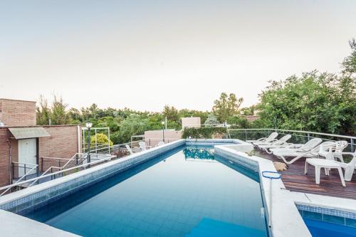 a swimming pool with chairs on a roof at Balcón del Diquecito in Villa Carlos Paz