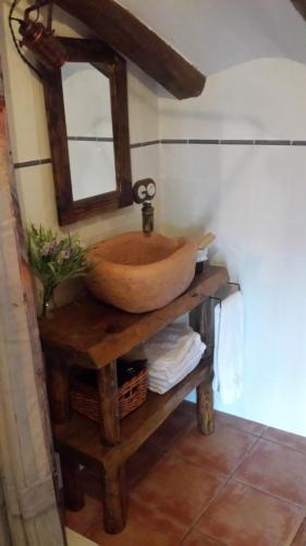 La salle de bains est pourvue d'un lavabo en bois sur une table. dans l'établissement El Bricial, à Bezas