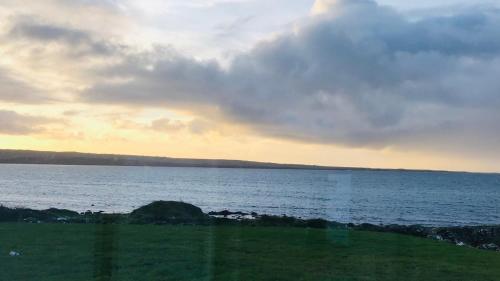 a view of a body of water with a cloudy sky at Spectacular ocean views & minutes to Cliffs- Clahane Shore Lodge in Liscannor