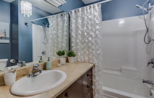 a bathroom with a sink and a tub and a shower at Condo Entre Ville/Nature in Magog-Orford