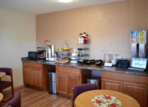 a kitchen with a counter with a table and chairs at Value Lodge Inn in Delta