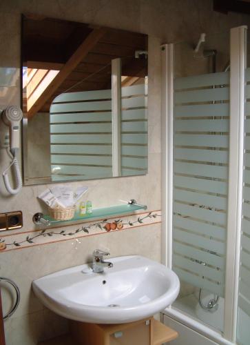 a bathroom with a sink and a mirror at Hotel Aldama Golf in Quintana de Llanes