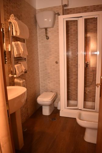 a bathroom with a toilet and a sink and a shower at Hotel Miravalle in Naples