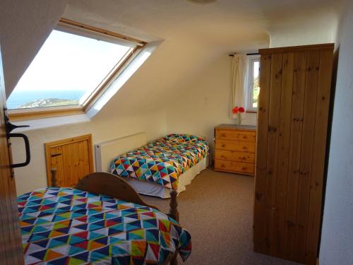 a bedroom with two beds and a window at Crohy Cottage in Donegal