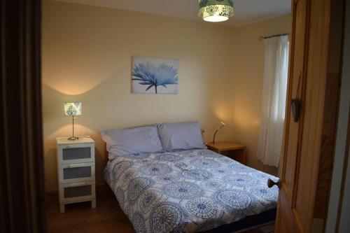 - une chambre avec un lit et une couette bleue dans l'établissement Teach Barney, à Falcarragh