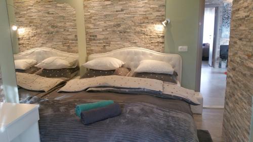 a large bed in a room with a brick wall at Villa Summer dream with heated pool, sauna and jacuzzi in Malinska