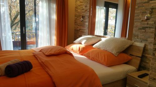 a bedroom with two beds with orange pillows and a window at Villa Summer dream with heated pool, sauna and jacuzzi in Malinska