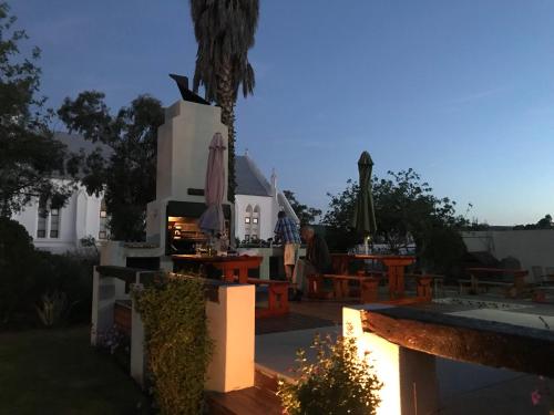 a man sitting at a table on a patio at Towerzicht Guest House in Ladismith