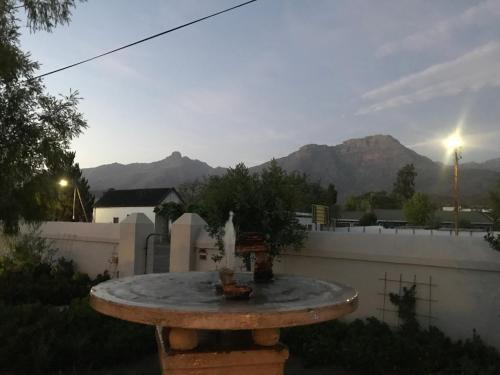 a fountain in a yard with mountains in the background at Towerzicht Guest House in Ladismith