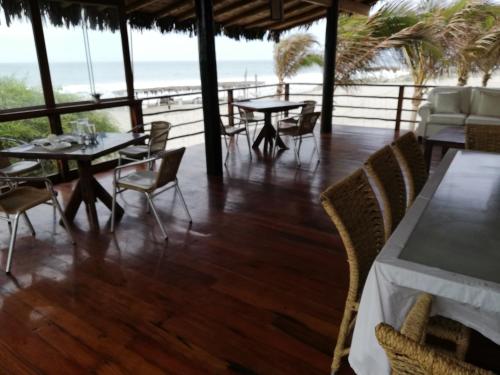a restaurant with tables and chairs and a view of the beach at Hotel Villa Sirena in Vichayito
