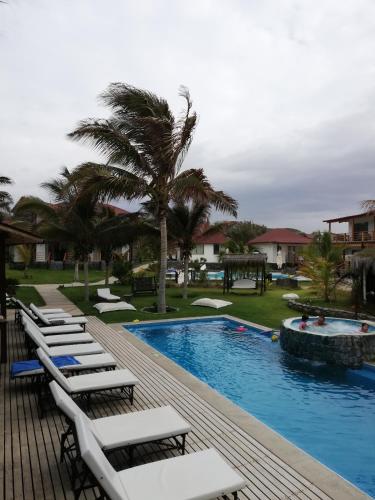 a row of lounge chairs next to a swimming pool at Hotel Villa Sirena in Vichayito