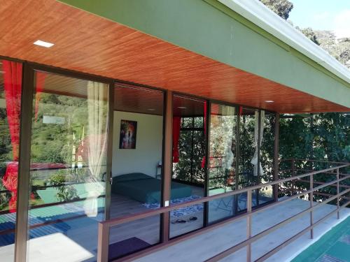 a glass house with a view of the yard at La Guayaba Monteverde in Monteverde Costa Rica
