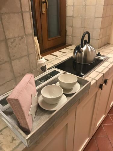 a kitchen counter with plates and a pot on a stove at La finestra sulla Toscana in Cortona