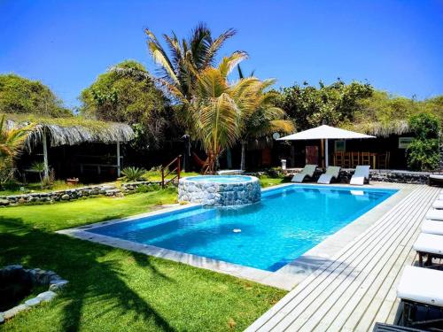 ein Pool in einem Garten mit Stühlen um ihn herum in der Unterkunft Hotel Villa Sirena in Vichayito