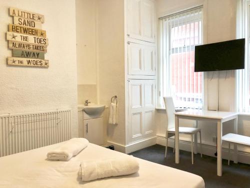 a bedroom with a bed and a desk and a sink at Empress Select Holiday Flats in Blackpool