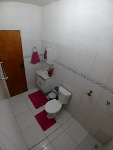 a white bathroom with a toilet and a sink at Casa Temporada com Ar cond e Wifi in Barreirinhas