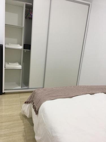 ラスパルマス・デ・グランカナリアにあるCaribbean Style Flatのベッドルーム(白いベッド1台、クローゼット付)