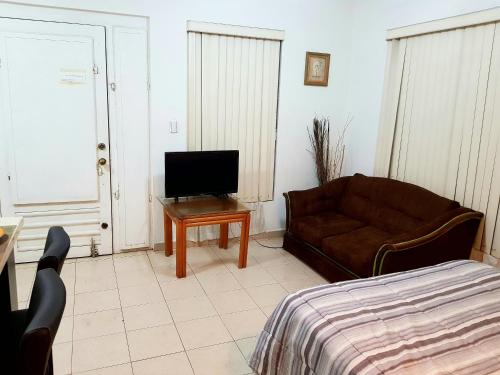 a living room with a couch and a television at Contry La Silla Apartments zona tec - Nuevo Sur in Monterrey