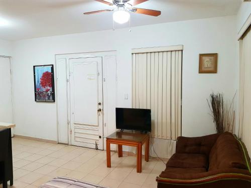 a living room with a couch and a flat screen tv at Contry La Silla Apartments zona tec - Nuevo Sur in Monterrey