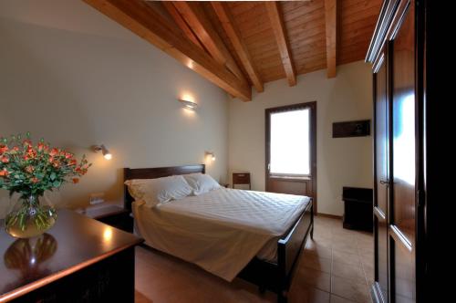 a bedroom with a bed and a vase of flowers on a table at Agriturismo Olistella in Palazzolo dello Stella