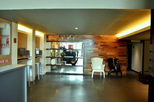 une chambre avec deux chaises blanches et une cuisine dans l'établissement Vivo Hotel, à Kuantan