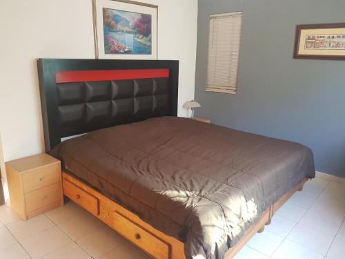 a bedroom with a large bed with a wooden frame at Contry La Silla Apartments zona tec - Nuevo Sur in Monterrey