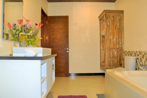 a bathroom with a wooden cabinet and a sink at Ocean Terrace Suite And Spa Luxury in Nusa Penida
