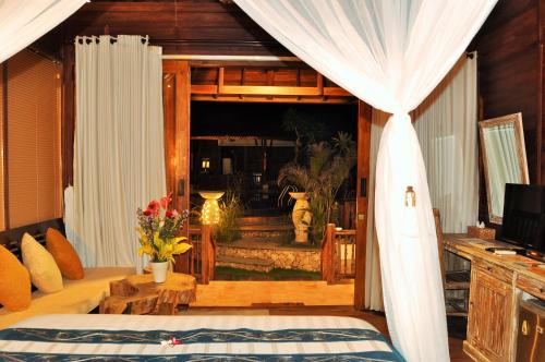 a bedroom with a bed and a view of a room at Ocean Terrace Suite And Spa Luxury in Nusa Penida