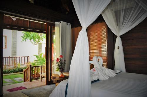 a bedroom with a bed with a canopy at Ocean Terrace Suite And Spa Luxury in Nusa Penida