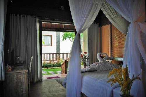 a bedroom with a bed with a canopy at Ocean Terrace Suite And Spa Luxury in Nusa Penida