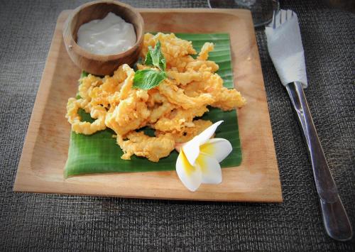 a plate of food with a flower on a banana leaf at Ocean Terrace Suite And Spa Luxury in Nusa Penida