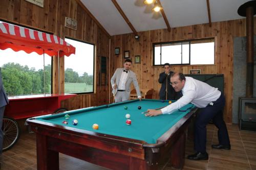 a group of people playing pool in a room at Cabañas de la Barra in Villarrica