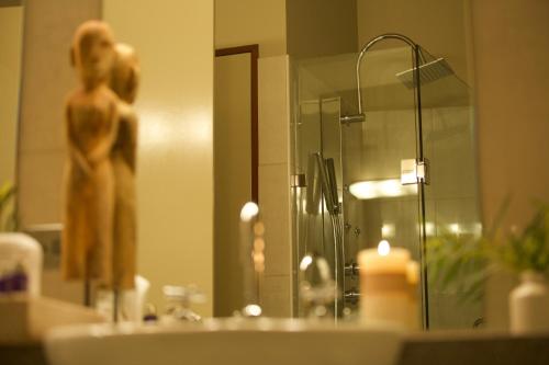 a bathroom sink with a mirror and a statue of a woman at Ironstone Romantic Couples Retreat in Halls Gap
