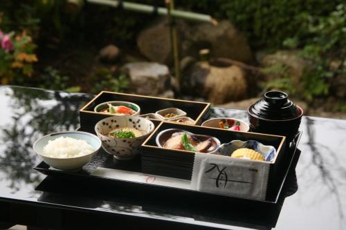 京都市にあるホテルオークラ京都のテーブルの上に食べ物の入ったトレイとボウル