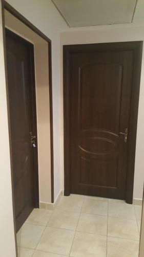 an empty room with two doors and a tile floor at Zatishok Guest House in Rakhiv