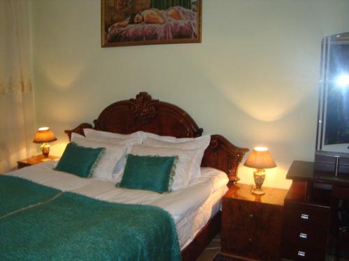 エレバンにあるLux Apartmentのベッドルーム1室(緑と白の枕が備わるベッド1台付)
