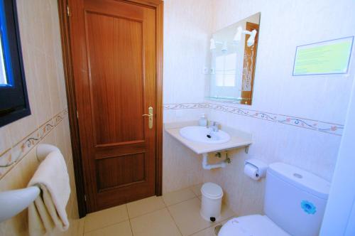 a bathroom with a toilet and a sink and a mirror at La Graciosa Punta Caracol in Caleta de Sebo
