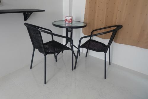 two black chairs and a table and a table and chairs at Airport Pearl Residence in Nai Yang Beach