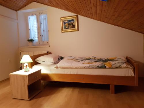 a bedroom with a bed and a table with a lamp at Cres view apartments in Cres