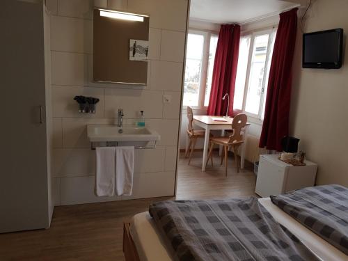 a bedroom with a bed and a sink and a table at Interlaken Apartments in Interlaken