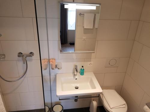 a small bathroom with a sink and a shower at Interlaken Apartments in Interlaken