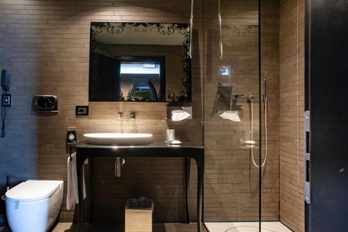 La salle de bains est pourvue d'un lavabo, d'un miroir et de toilettes. dans l'établissement Hotel Palazzo Barbarigo Sul Canal Grande, à Venise